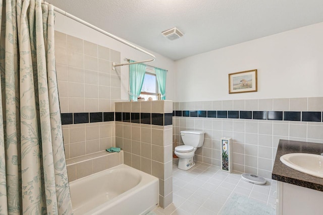 full bathroom featuring visible vents, tile patterned flooring, a textured ceiling, tile walls, and toilet