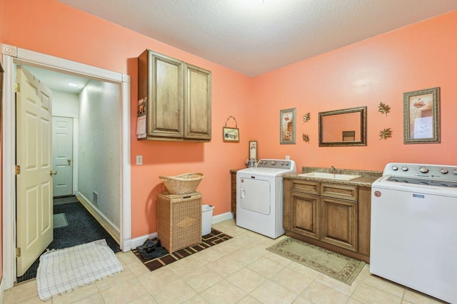 laundry area with baseboards, cabinet space, a textured ceiling, independent washer and dryer, and a sink