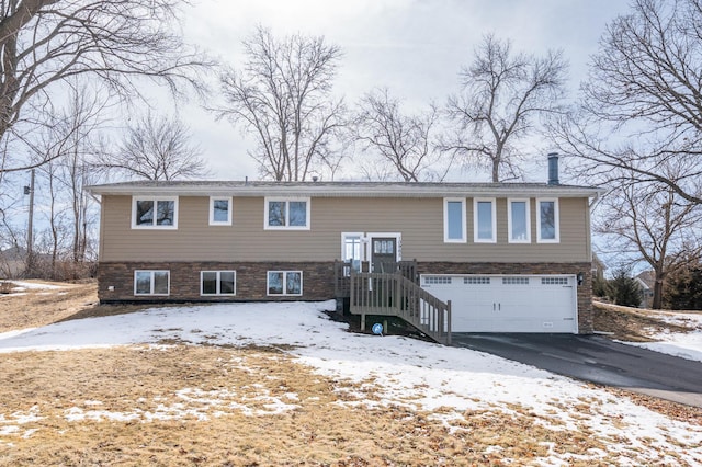 raised ranch featuring driveway and an attached garage