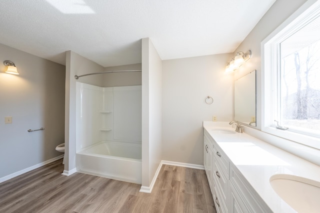 bathroom featuring plenty of natural light, wood finished floors, and a sink