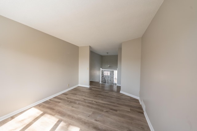 spare room with wood finished floors and baseboards