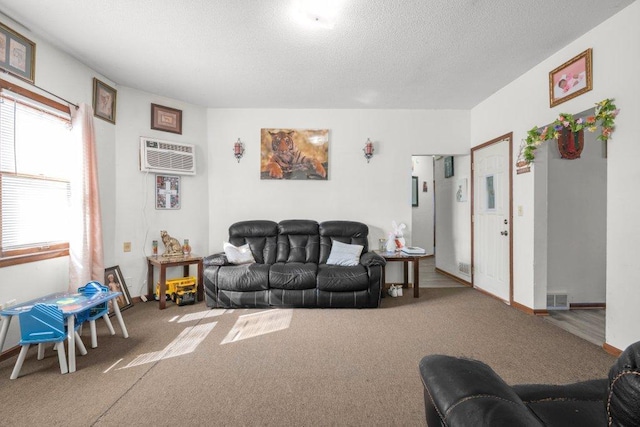 living area with visible vents, a textured ceiling, baseboards, and carpet floors