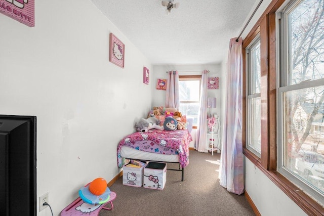 carpeted bedroom with baseboards and a textured ceiling