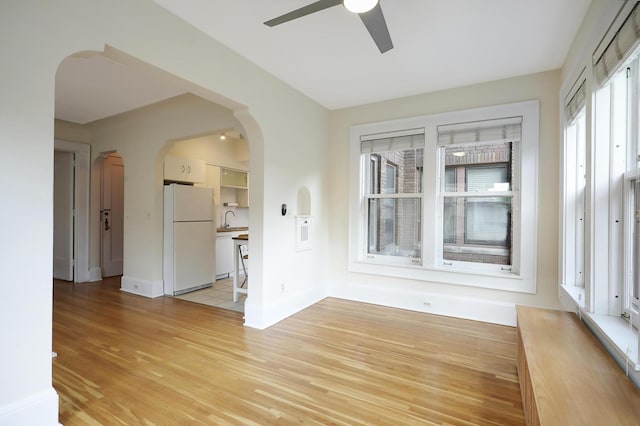 2606 Humboldt Ave S Unit 6, Minneapolis, MN 55408 - empty room with light wood-style floors, arched walkways, a sink, ceiling fan, and baseboards