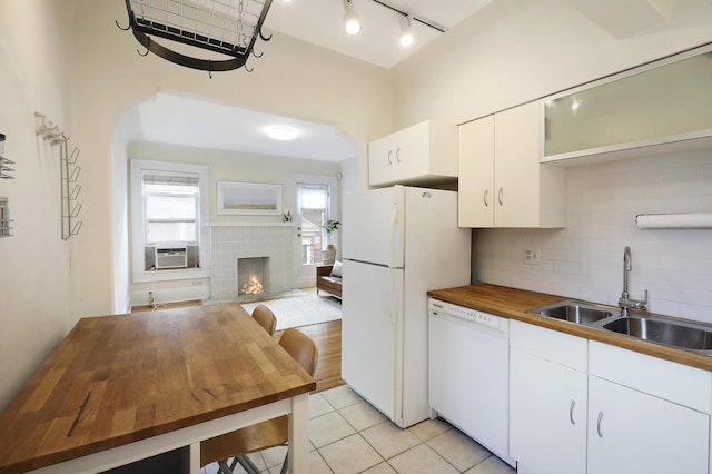 2606 Humboldt Ave S Unit 6, Minneapolis, MN 55408 - kitchen featuring white appliances, butcher block countertops, a sink, a tiled fireplace, and backsplash