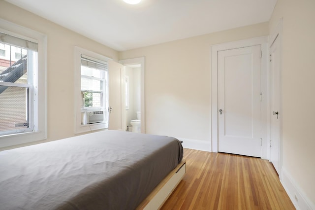 2606 Humboldt Ave S Unit 6, Minneapolis, MN 55408 - bedroom with light wood finished floors, baseboards, cooling unit, and ensuite bathroom