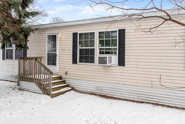 snow covered property entrance featuring crawl space