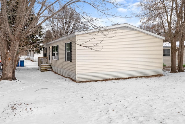 snow covered property with cooling unit