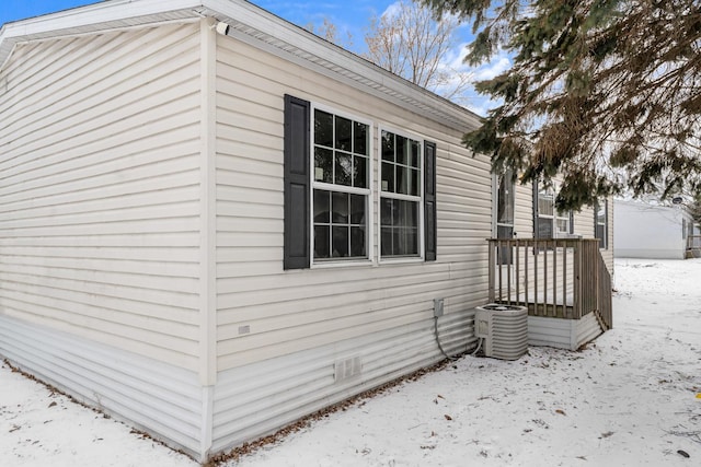 snow covered property with central AC