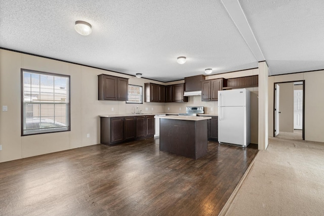 kitchen featuring stainless steel electric range, freestanding refrigerator, dark brown cabinetry, light countertops, and a center island