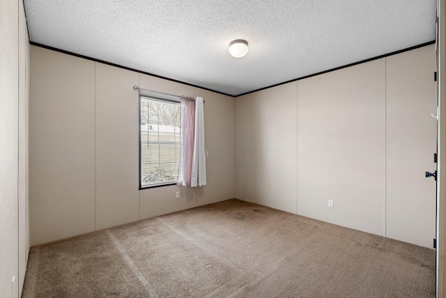 unfurnished room with a textured ceiling, crown molding, and carpet floors