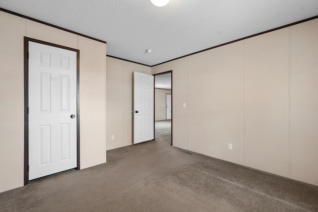 unfurnished bedroom with ornamental molding, a textured ceiling, and carpet floors