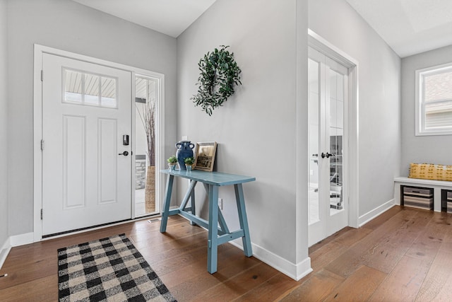 foyer entrance featuring wood-type flooring and baseboards