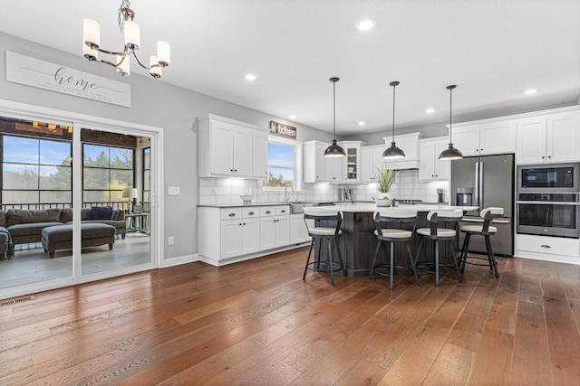 kitchen with dark wood finished floors, visible vents, stainless steel appliances, and white cabinets