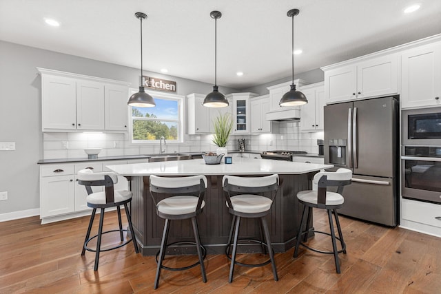 kitchen with a center island, a sink, backsplash, and stainless steel appliances