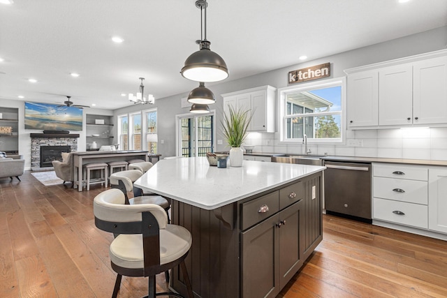 kitchen featuring hardwood / wood-style floors, recessed lighting, dishwasher, and a sink