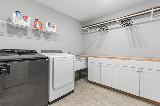 washroom featuring marble finish floor, cabinet space, and independent washer and dryer