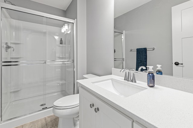 full bath featuring a stall shower, toilet, and vanity