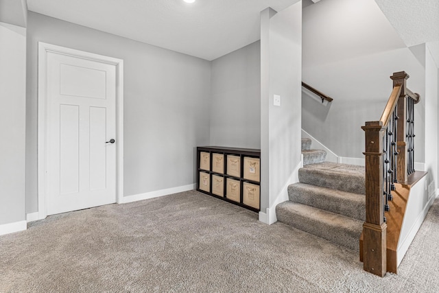 stairway with baseboards and carpet floors