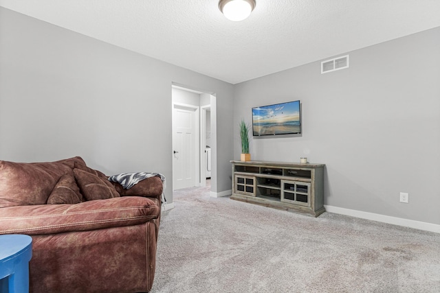 living area featuring a textured ceiling, visible vents, carpet flooring, and baseboards