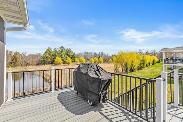 deck with a water view and a lawn