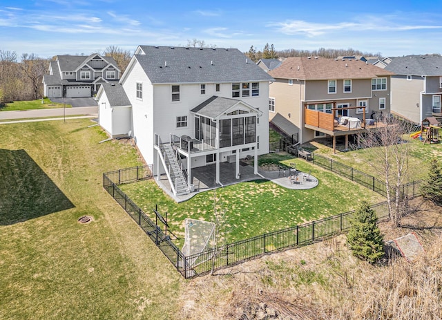 back of property featuring a wooden deck, a fenced backyard, a residential view, and a sunroom