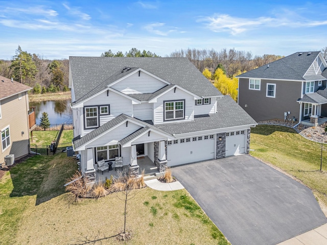 traditional-style house featuring a front lawn, central air condition unit, a shingled roof, aphalt driveway, and fence