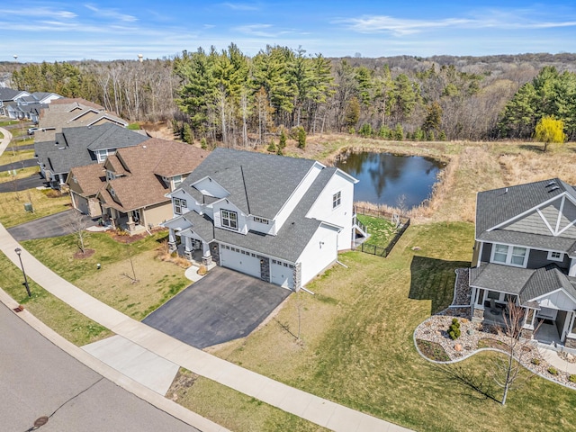 birds eye view of property featuring a wooded view, a residential view, and a water view