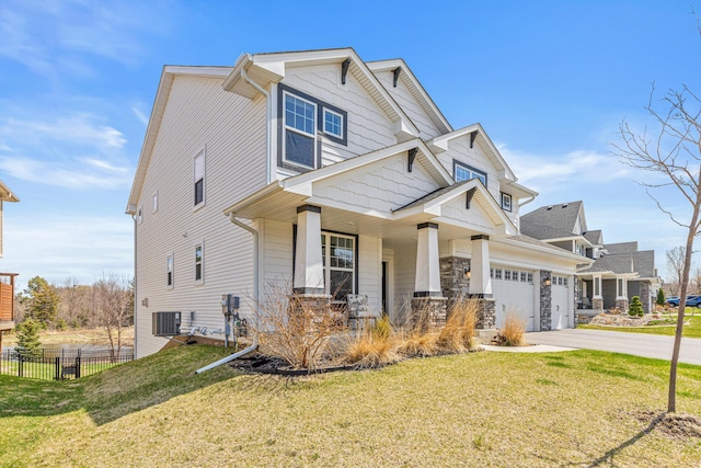 craftsman-style house with fence, a porch, a front lawn, and a garage