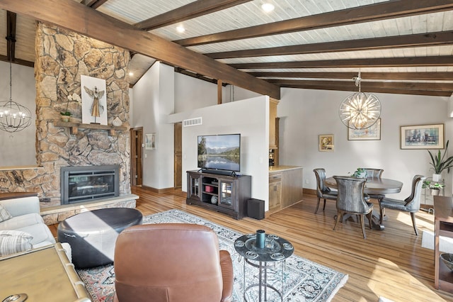 living area with visible vents, light wood-type flooring, and an inviting chandelier