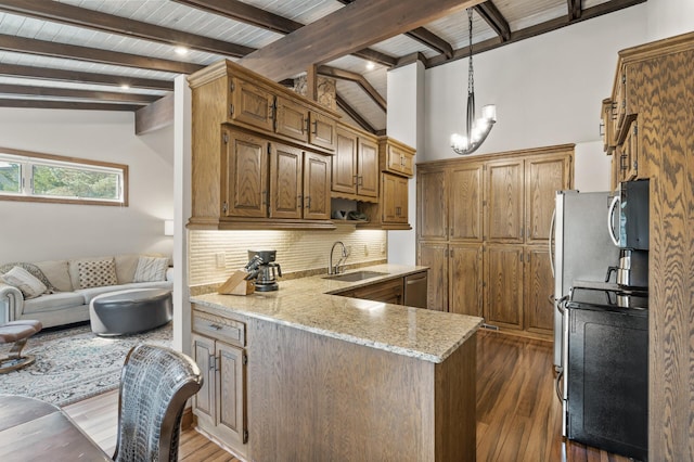 kitchen featuring a sink, lofted ceiling with beams, backsplash, stainless steel appliances, and a peninsula