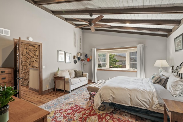 bedroom featuring wood finished floors, visible vents, baseboards, vaulted ceiling with beams, and wood ceiling