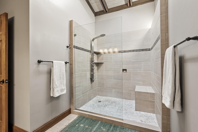 full bathroom featuring baseboards and tiled shower