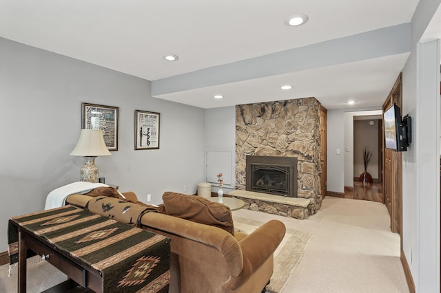 living room featuring a stone fireplace, carpet flooring, recessed lighting, and baseboards