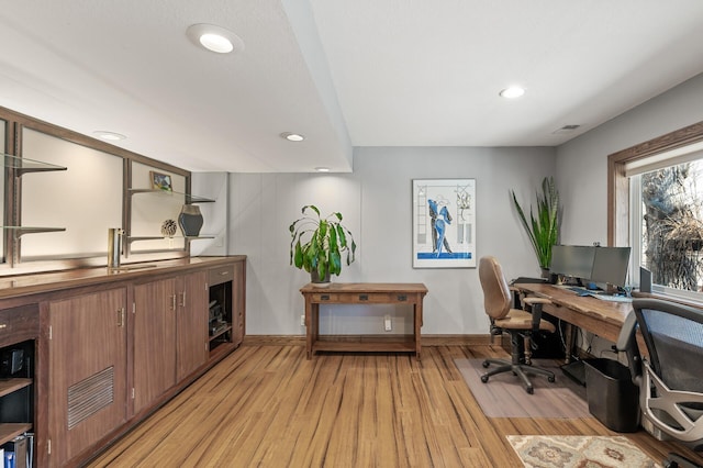 office space with recessed lighting, baseboards, visible vents, and light wood finished floors