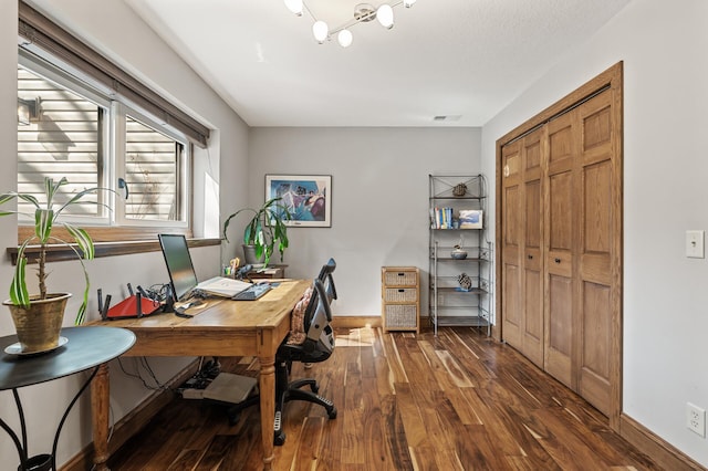 office area with visible vents, baseboards, and wood finished floors