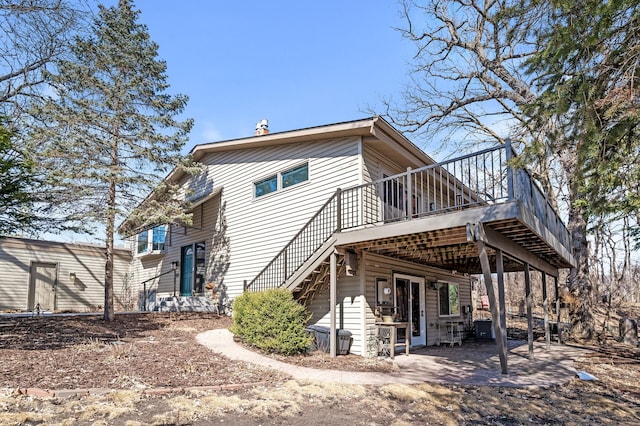 rear view of property featuring stairs, a patio, and a deck