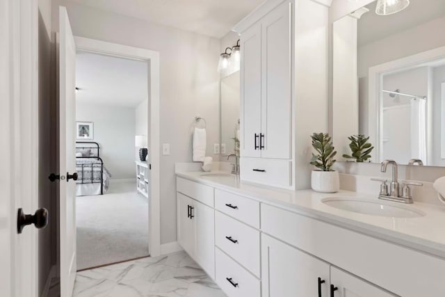 bathroom with double vanity, baseboards, marble finish floor, and a sink