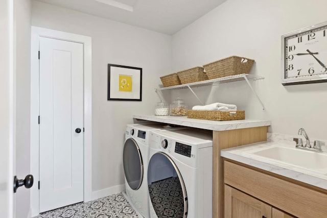 clothes washing area with baseboards, washing machine and dryer, laundry area, light tile patterned flooring, and a sink