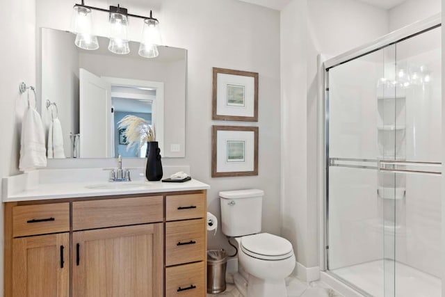 bathroom featuring vanity, a shower stall, toilet, and baseboards