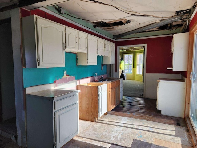 kitchen featuring white cabinetry and a sink