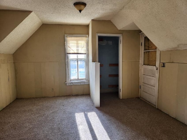 bonus room featuring lofted ceiling, a textured ceiling, and carpet floors