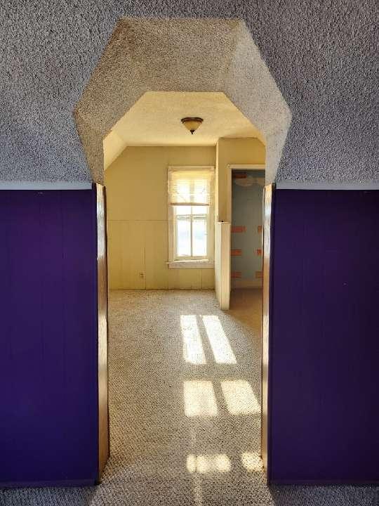 additional living space with a textured ceiling and lofted ceiling