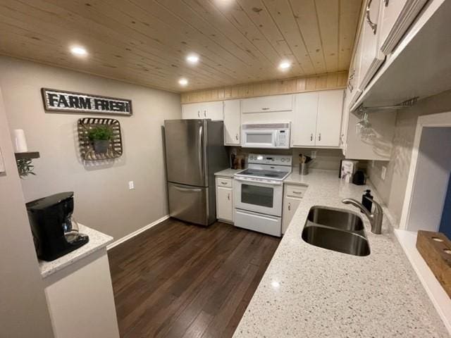 kitchen with a sink, dark wood finished floors, white appliances, white cabinets, and wooden ceiling