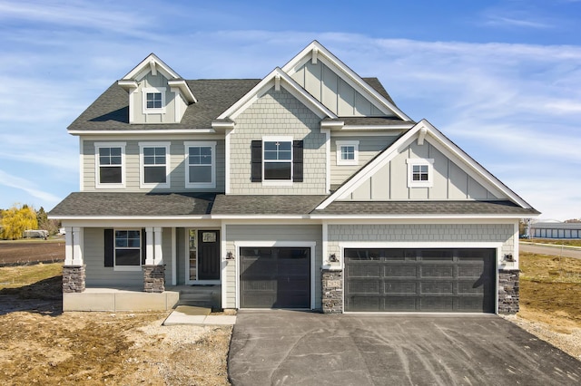 craftsman inspired home featuring stone siding, board and batten siding, driveway, and a shingled roof