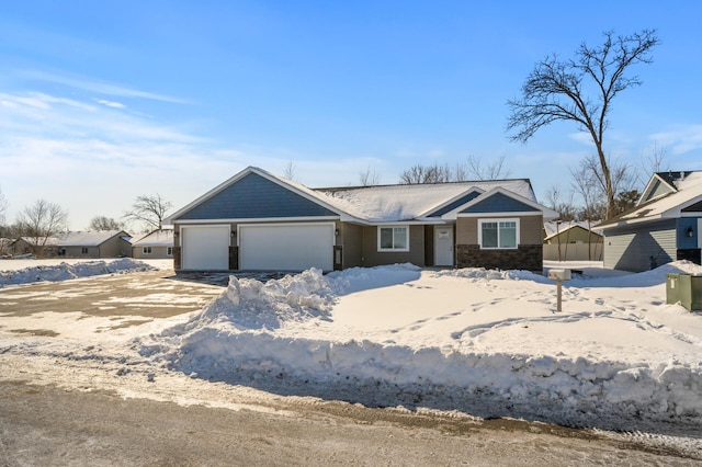 view of front of house with stone siding, driveway, and a garage