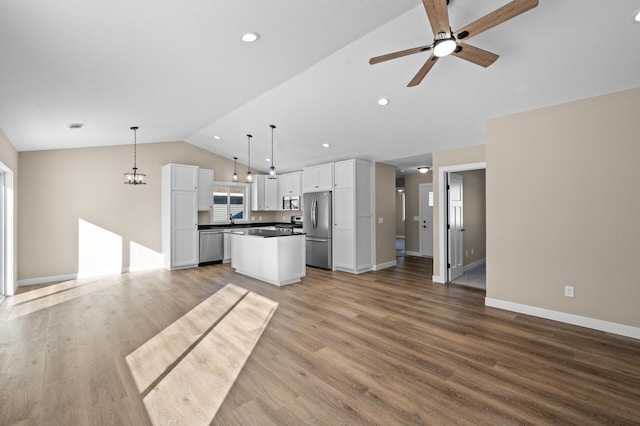 kitchen featuring lofted ceiling, ceiling fan, white cabinets, appliances with stainless steel finishes, and open floor plan