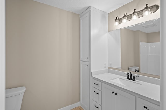 bathroom featuring baseboards, toilet, vanity, and tile patterned flooring