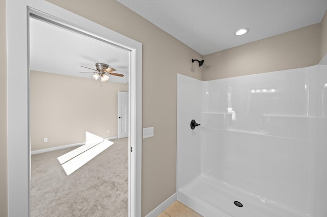 full bathroom with a shower, baseboards, a textured ceiling, and ceiling fan