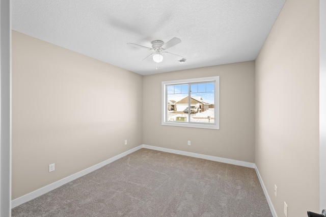 carpeted empty room featuring a textured ceiling, baseboards, and a ceiling fan